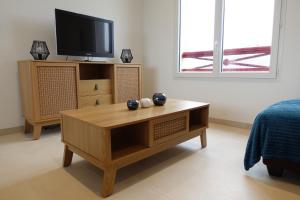 a living room with a tv and a coffee table at Cocon moderne avec terrasse a deux pas de locean in Saint-Brevin-les-Pins