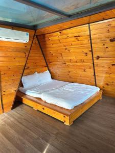 Phú ÐứcにあるHomestay Hồ Senの木製の壁のドミトリールーム(ベッド1台)