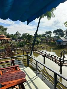 Phú ÐứcにあるHomestay Hồ Senの川橋の上に座る木製のベンチ