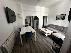 a living room with a couch and a table at Le Havre de paix vue sur piscine in Larche
