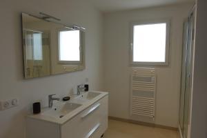 a white bathroom with a sink and a mirror at Cocon moderne avec terrasse a deux pas de locean in Saint-Brevin-les-Pins +28 photos