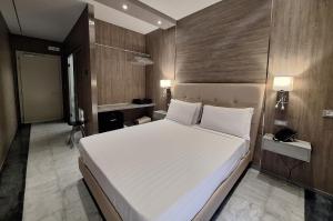 a bedroom with a large white bed and wooden walls at Hotel Tre Ville in Parma