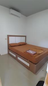 un lit dans une chambre blanche avec publicité dans l'établissement Madak ekas homestay 2, à Ekas