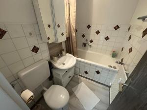 a bathroom with a sink and a toilet and a tub at Boho Apartment Birkenstöckl in Bad Reichenhall +13 photos