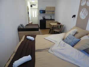 a large bed in a room with a living room at Pogácsás II Apartman Tokaj in Tokaj