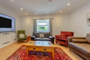 a living room with a couch and chairs and a tv at Pembrokeshire Near Beach With A Hot Tub in Pembroke