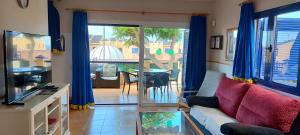 a living room with a couch and a sliding glass door at Bahía Meloneras in Meloneras