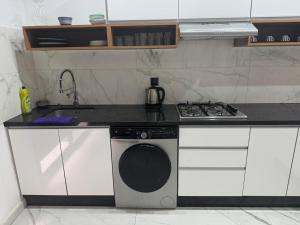 a kitchen with a stove and a washing machine at Iquama atawhid I in Nador