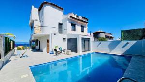 a villa with a swimming pool in front of a house at Villa jasmin in Çeşme