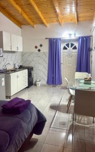 eine Küche mit lila Vorhängen und einem Tisch und einer Tür in der Unterkunft Monoambiente EK Centro Neuquén in Neuquén + 6 Fotos