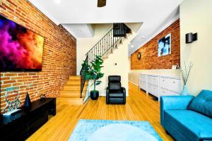 a living room with a blue couch and a brick wall at Federal Hill & Inner Harbor Lux Retreat Sleeps 6 in Baltimore