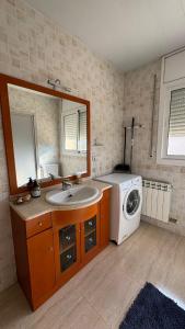 a bathroom with a sink and a washing machine at Casa ELPI in Guardiola +6 photos