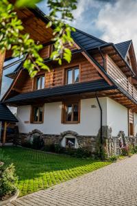 a wooden house with a gambrel roof at Chochołowska Zagroda in Chochołów
