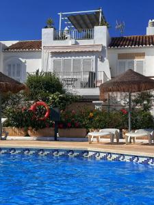 une maison avec une piscine devant une maison dans l'établissement Vera Playa La Medina, à Los Amarguillos