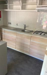 a kitchen with a sink and a stove at Bonne Anse plage 411 mobile home 3 chambres in Les Mathes