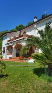 una casa blanca con una palmera delante de ella en Relax nella Natura en Bolano