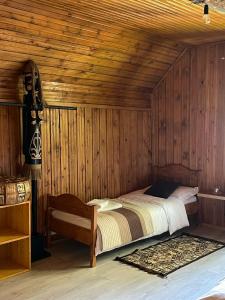 Un dormitorio con una cama en una pared de madera. en Cabana Mistic, en Bran