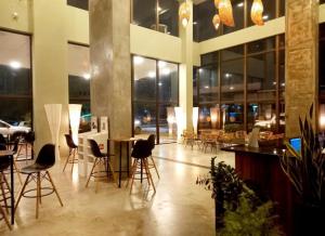 a lobby with chairs and tables in a building at Ilusion hotel ponta negra Natal in Natal