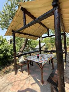 a table and a bench under a pavilion at Край отдыха дзорахбюур in Yerevan