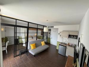 a living room with a couch and a kitchen at KLIO Apartments and Studios in Nei Poroi