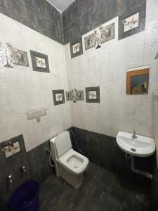 a bathroom with a toilet and a sink at LunaBloom Stays in Maraiyūr