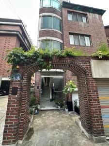 een boog voor een bakstenen gebouw met planten bij Ahyeon Station 10-minute walk Cozy Stay in Seoul
