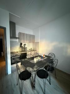 a kitchen with a table and chairs in a room at Cœur de ville au 1er 66M2, vu sur la place in Gap