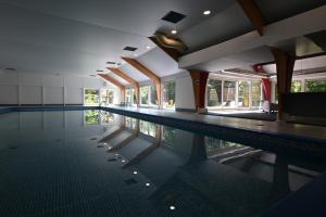 a swimming pool in a building with the water in it at Bosgeluk Durbuy in Durbuy