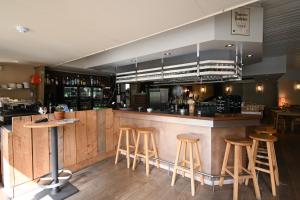 a bar in a restaurant with wooden stools at Bosgeluk Durbuy in Durbuy