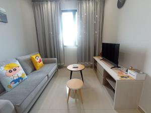 Una pequeña sala de estar con un sofá y un televisor. en Iconic Regency Service Residences - Bee's Home, en Bayan Lepas 82 fotos más