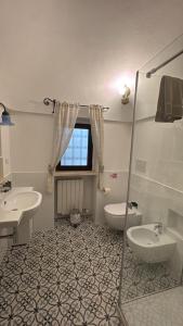 a bathroom with two sinks and a toilet and a window at TRULLO FERNANDO in San Michele Salentino +35 photos