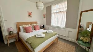 a bedroom with a bed with pink and green pillows at Chester City Centre Apartments in Chester