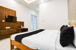 una camera da letto con un letto e una TV a parete di Hotel O The Grand Blue Hotel a Noida Altre 22 foto