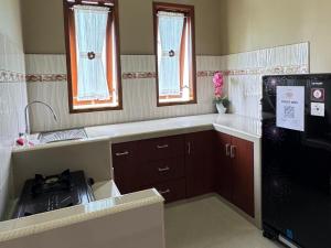 a kitchen with a sink and a refrigerator at Villa Ostara Kota Batu in Batu +9 photos