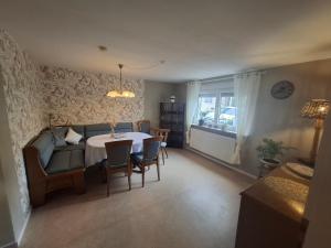 a living room with a table and chairs and a couch at Ferienwohnung Vey in Hilders