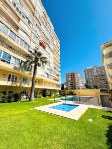 a palm tree in front of a large building at Apartamento Bougainvillea in Fuengirola