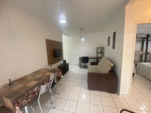 a living room with a table and a couch at Apartamento Buenos Aires, próximo hospital Caridade in Santa Maria