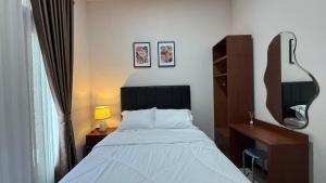 a bedroom with a bed and a desk and a mirror at Villa Ostara Kota Batu in Batu