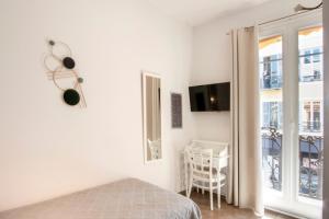 a white bedroom with a bed and a window at Hotel Lepante in Nice +39 photos