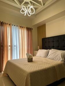 ein Schlafzimmer mit einem großen Bett und einem Deckenventilator in der Unterkunft Cozeo Nest Tagaytay- SMDC Wind Residences in Kaybagal