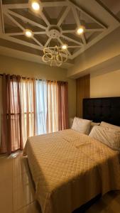 ein Schlafzimmer mit einem großen Bett mit Decke in der Unterkunft Cozeo Nest Tagaytay- SMDC Wind Residences in Kaybagal