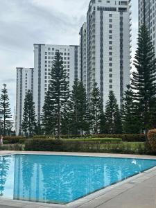 ein Schwimmbad vor einigen hohen Gebäuden in der Unterkunft Cozeo Nest Tagaytay- SMDC Wind Residences in Kaybagal