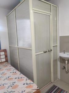 a bedroom with a shower backdoor with a sink at bungalow in the heart of Gangapur Road Nashik in Nashik +28 photos