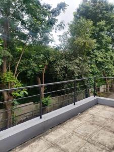 a balcony with a fence and trees in the background at bungalow in the heart of Gangapur Road Nashik in Nashik