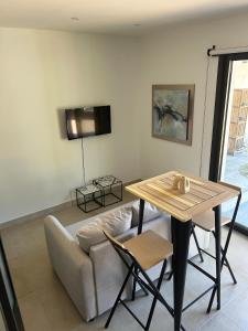 a living room with a table and a couch at Le cocon de Malo in Lecci