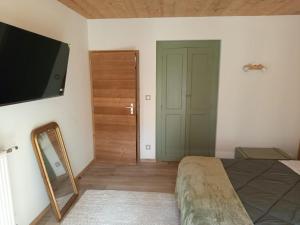 um quarto com uma cama, um espelho e uma televisão em Le Chablis'cîmes em Champagnole