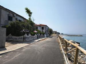 an empty street next to the ocean with a building at B&B Villa Gubitosi in Cittadella del Capo