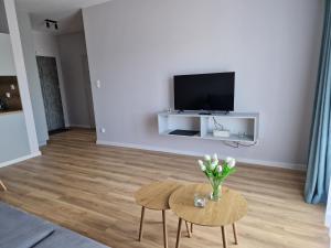 a living room with a vase of flowers on a table at Apartament ulica Marzeń 13 in Kostrzyn nad Odrą
