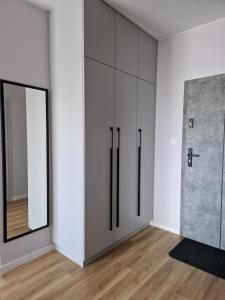 a room with white cabinets and a mirror at Apartament ulica Marzeń 13 in Kostrzyn nad Odrą