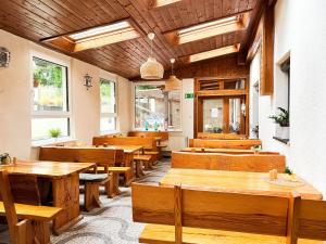 a restaurant with wooden tables and benches and windows at VILLA SUNNY ROSE Bed & Breakfast in Świnoujście